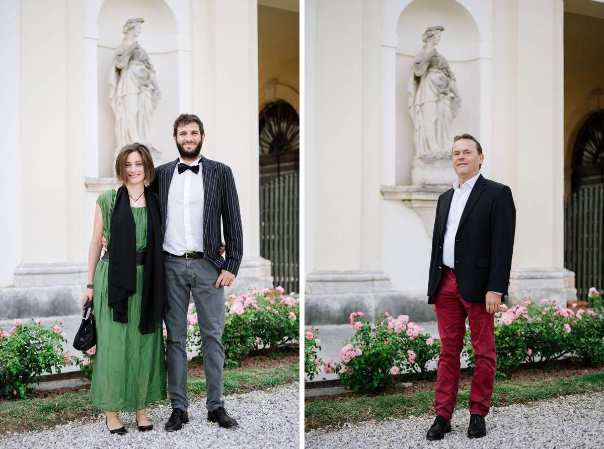 Formal attire portraits in front of white architectural facade with statue and garden.