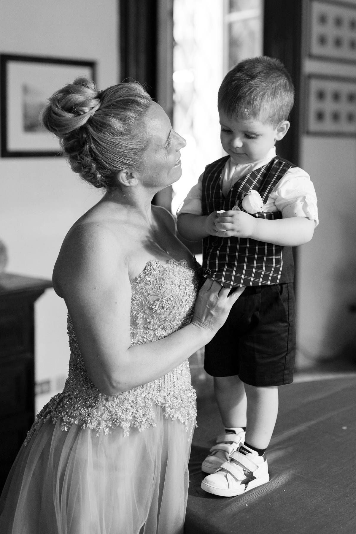 A tender moment between a person in a formal gown and small child in formal attire.