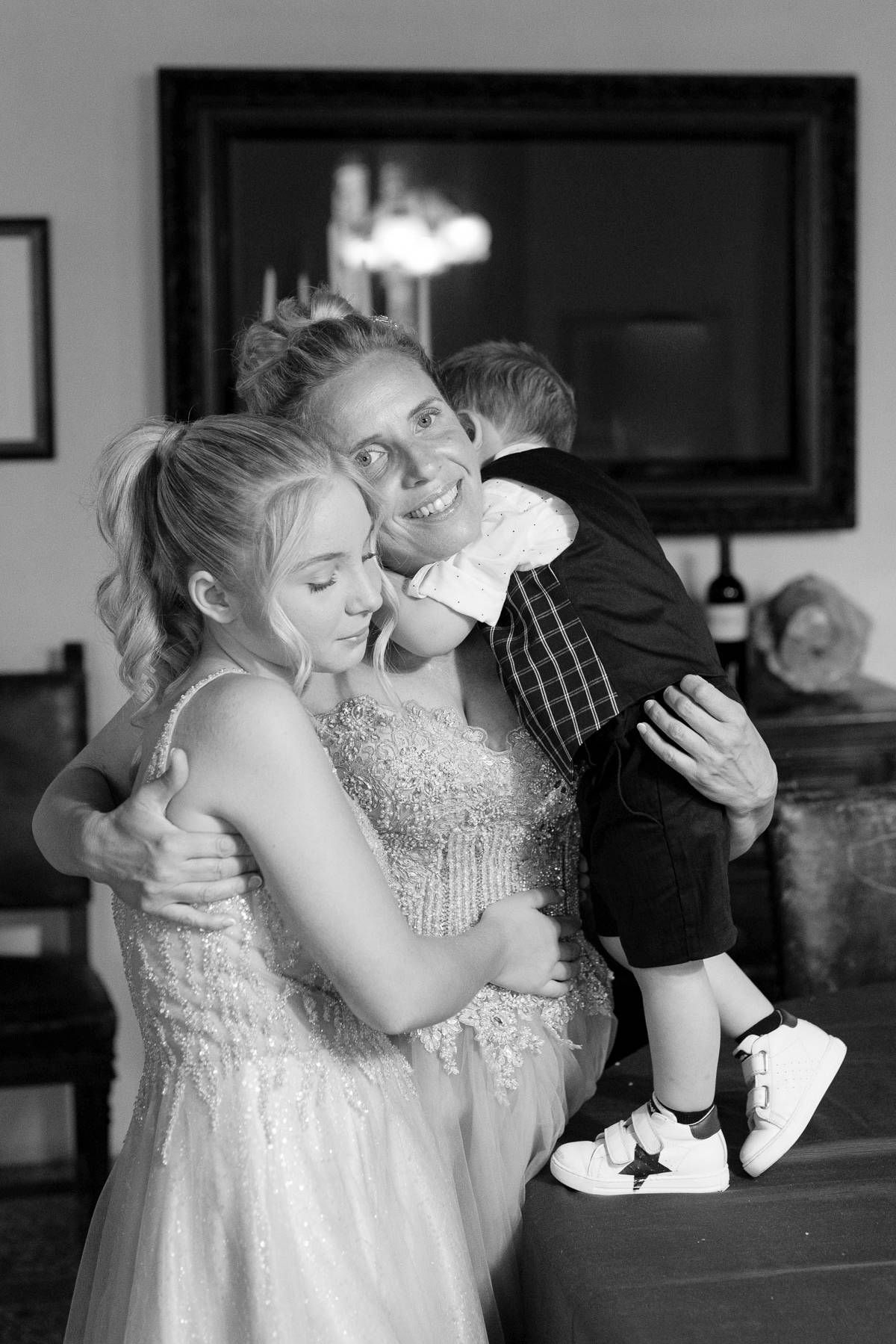 An emotional black and white photo capturing a group embrace during a special occasion.