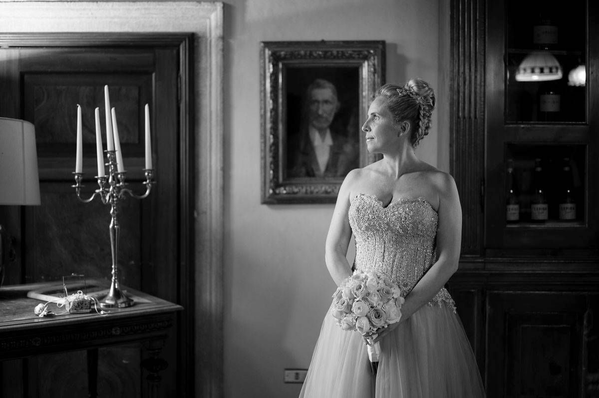 Elegant black and white portrait showing a person in a wedding gown next to a candelabra.