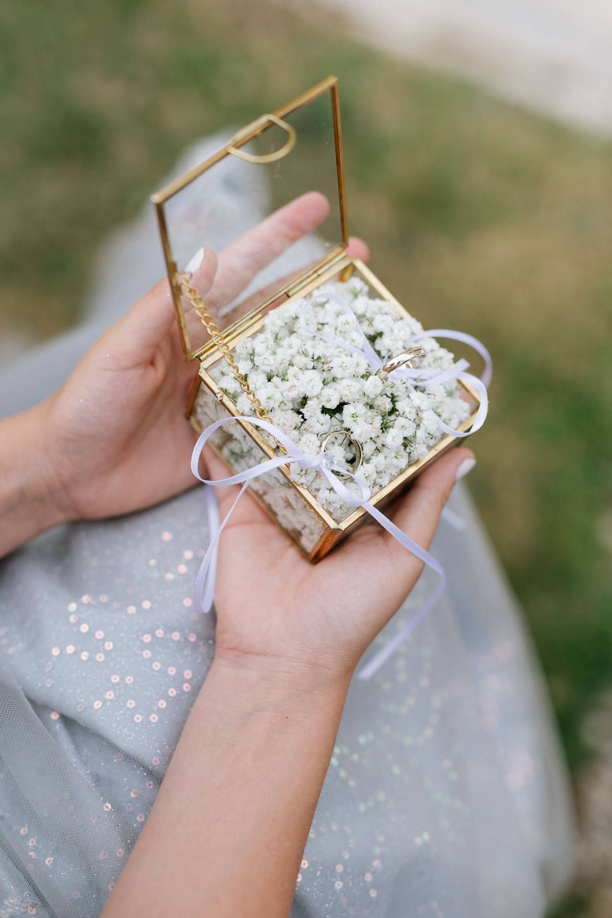 Delicate white baby's breath flowers nestled in a vintage-style glass and brass box.