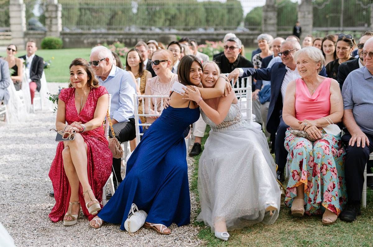 Wedding guests in colorful attire share emotional moments during the ceremony.
