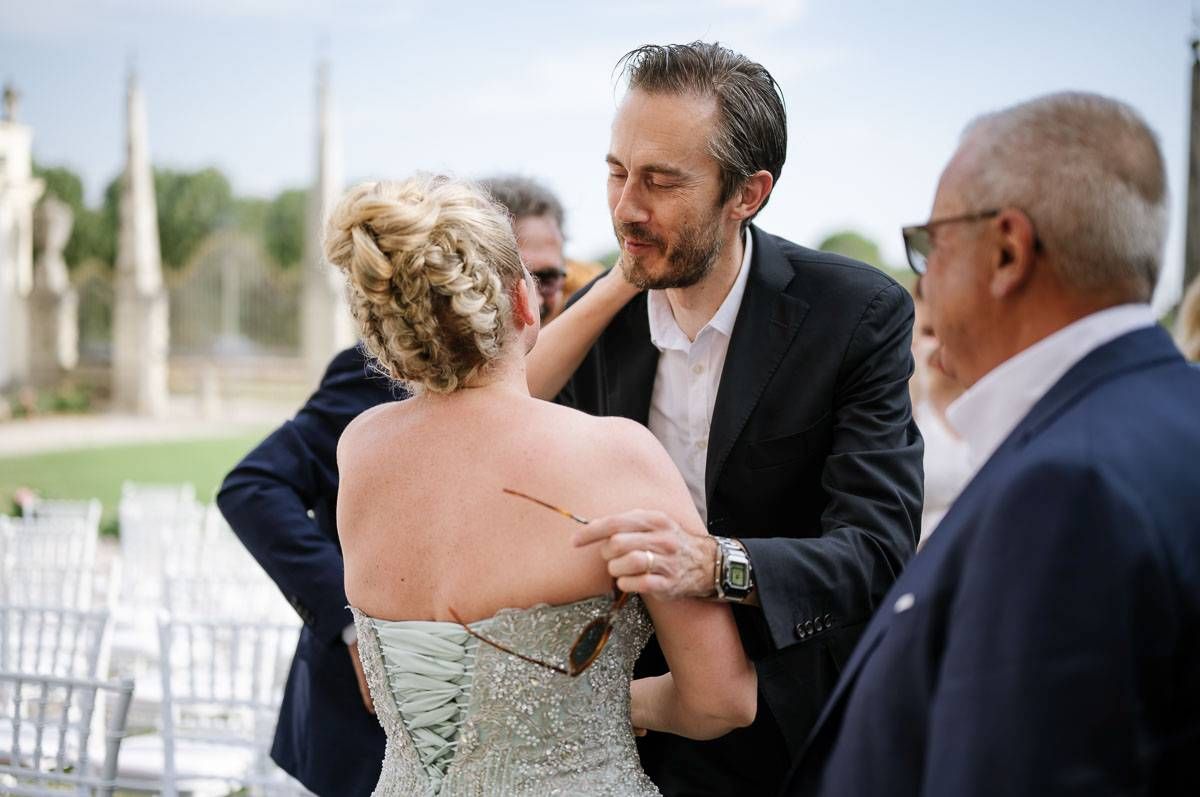 Outdoor wedding ceremony interaction with bride in strapless dress.