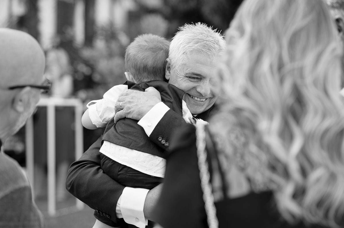Black and white photo of joyful moment with small child at formal event.