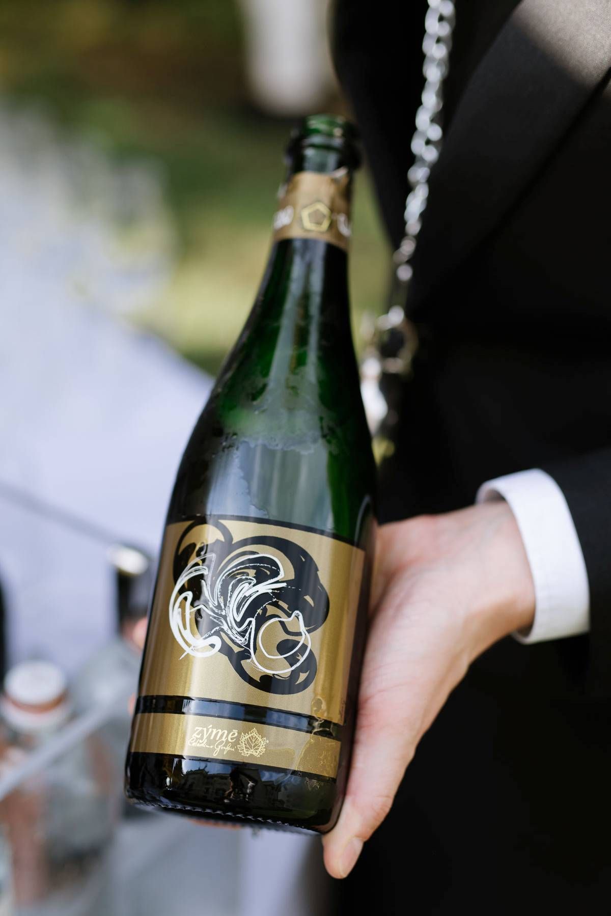 Close up of ornate wine bottle being held at formal event.