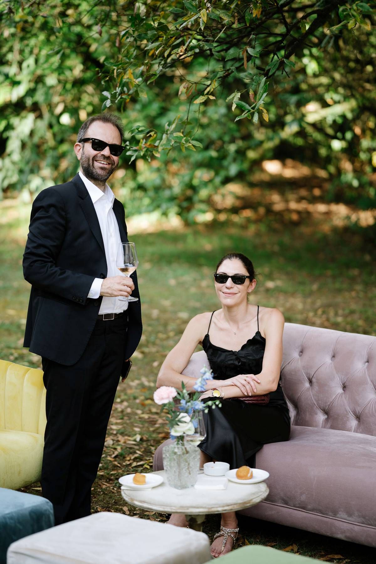 Stylish outdoor lounge setup with vintage sofa and side table at a garden party.