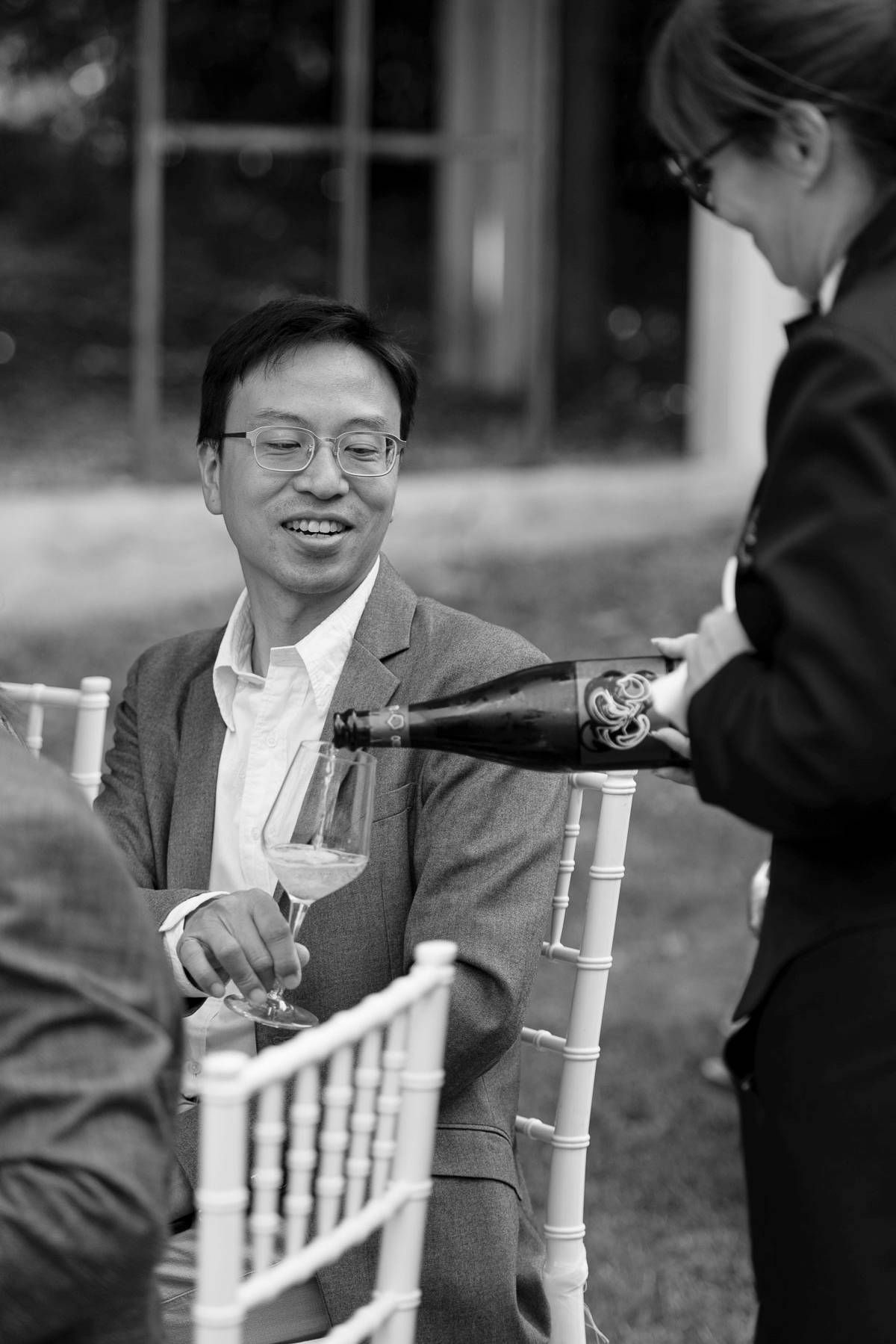 Wine service at an elegant outdoor event with chiavari chairs.