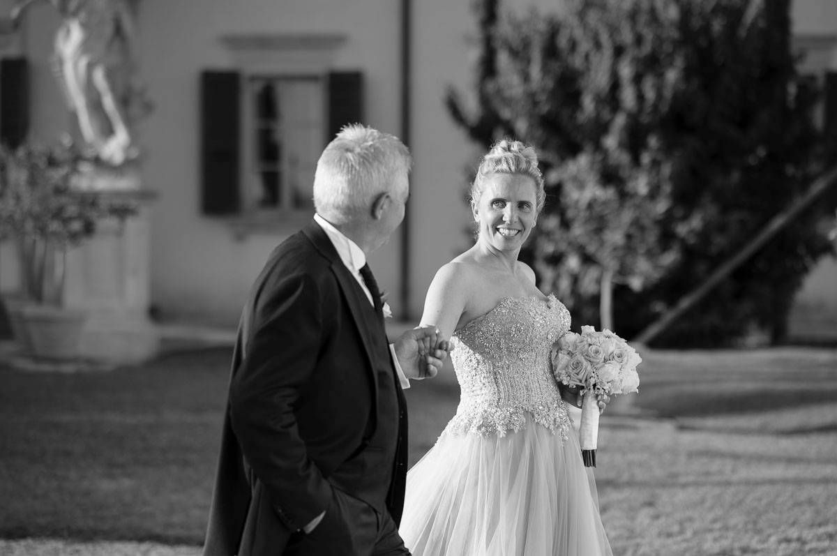 Black and white portrait of couple in formal attire by historic building.