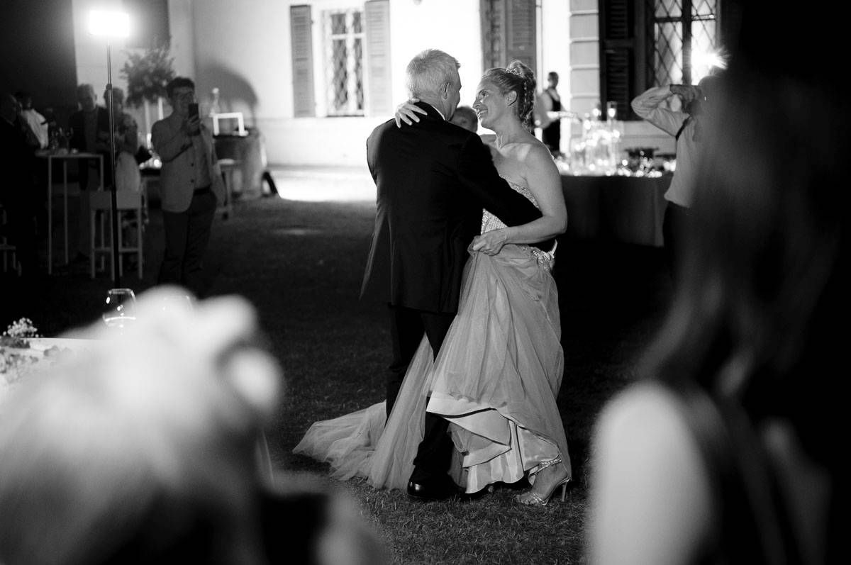Couple dances together at evening wedding reception in black and white.