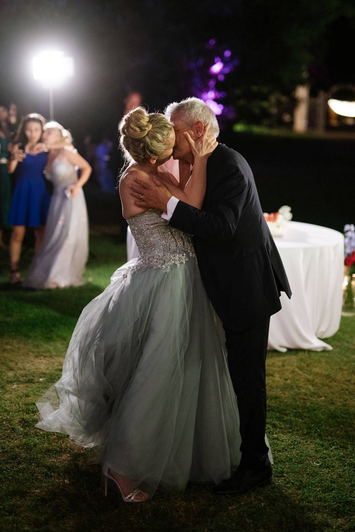 Romantic dance moment captured during nighttime outdoor wedding celebration.