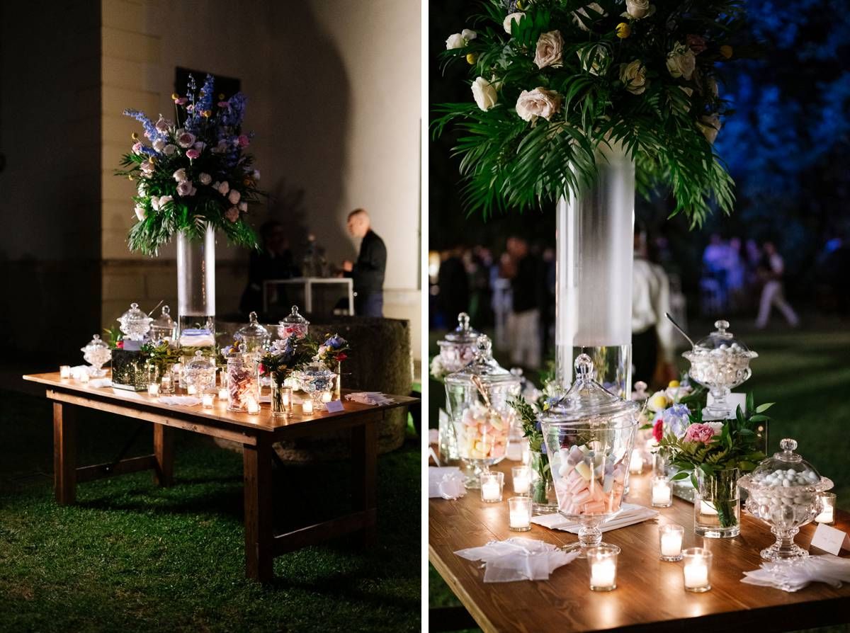 Elegant wedding reception table setup with tall floral arrangements and glowing candles.