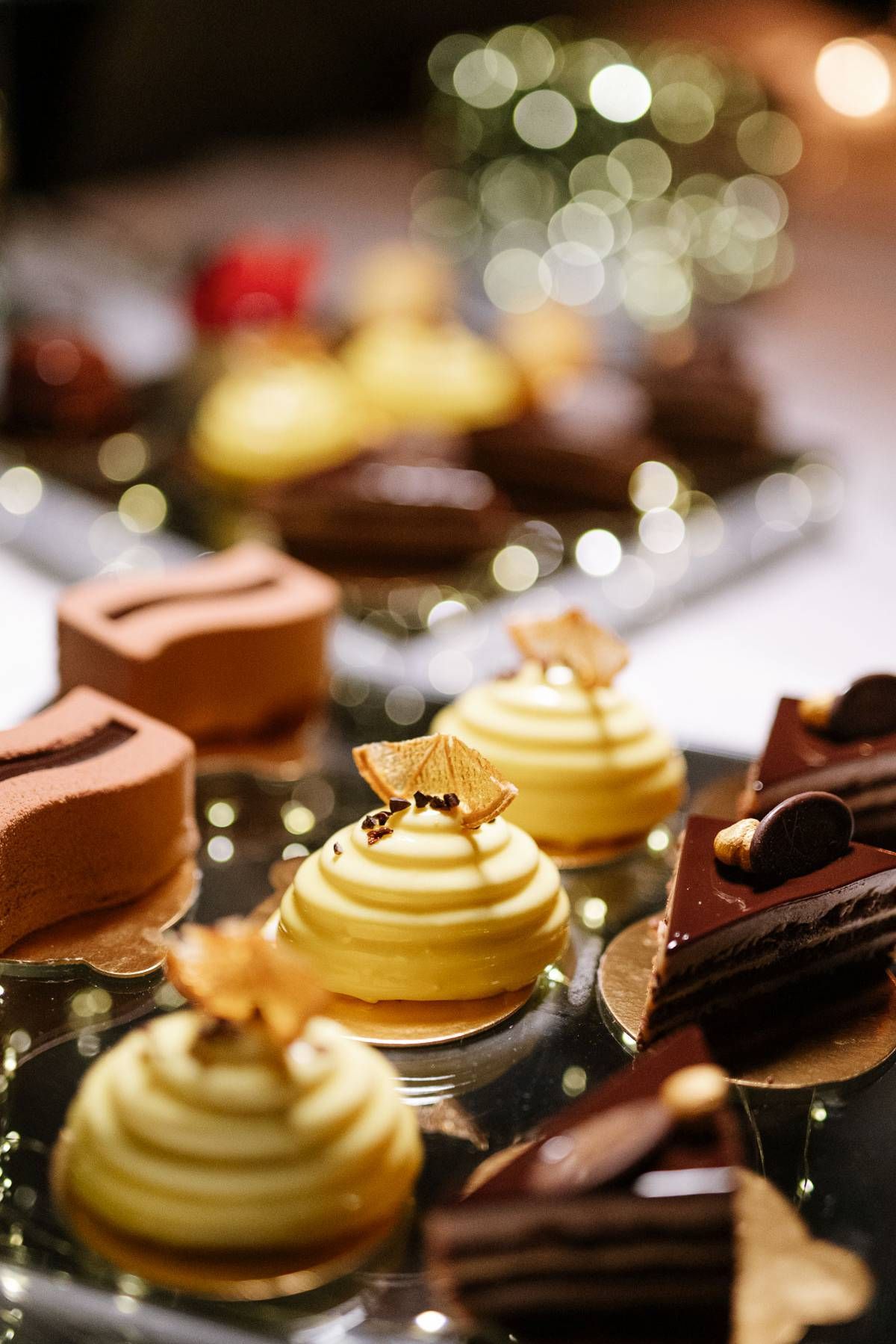 Artfully decorated desserts featuring chocolate and cream pastries with gold accents.