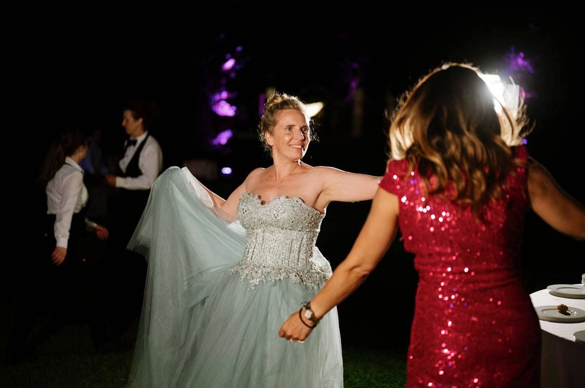Two dancers enjoy a lively moment on the dance floor with purple lighting and evening ambiance.