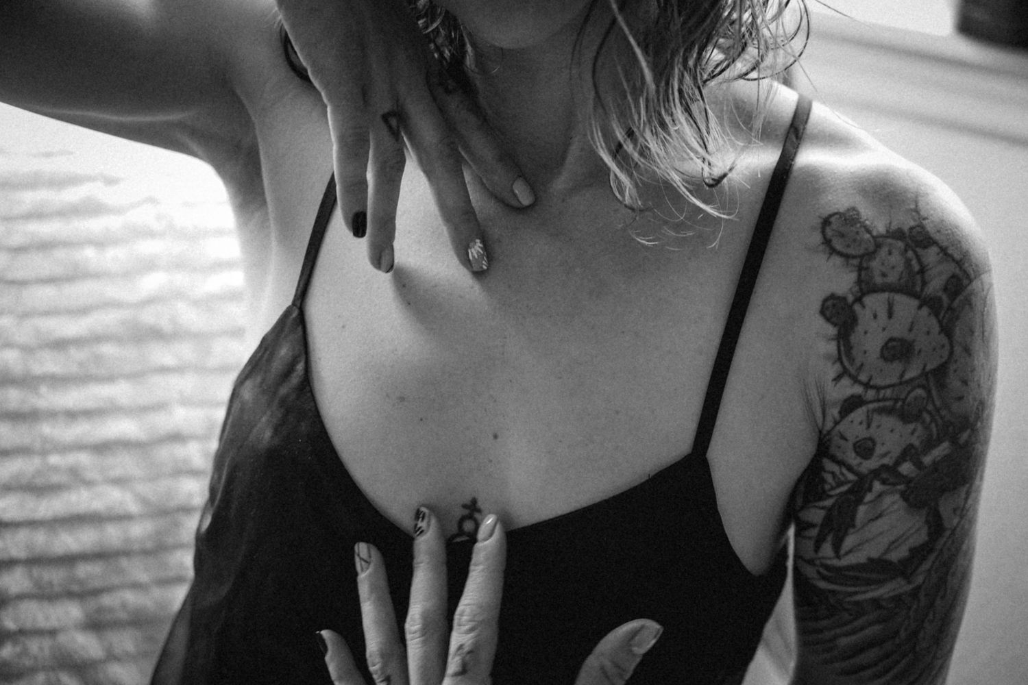 Close-up black and white photo showing detailed floral tattoo on shoulder.
