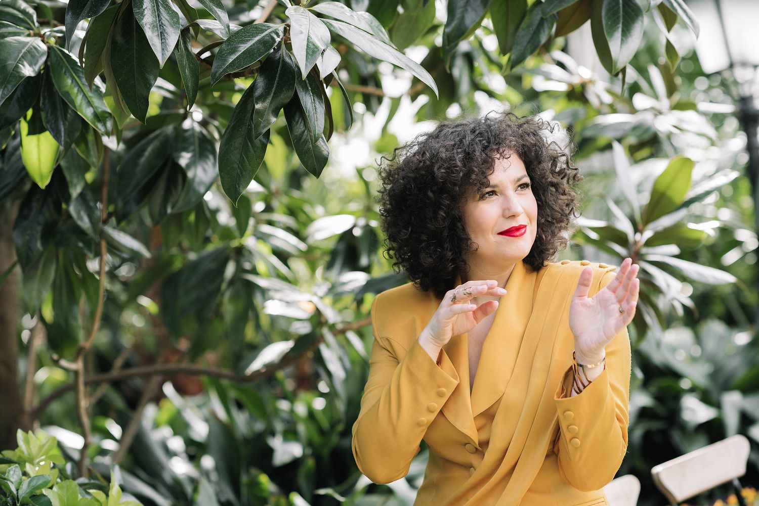Satu Heihinheimo modern business headshot yellow dress in greenery backgroung
