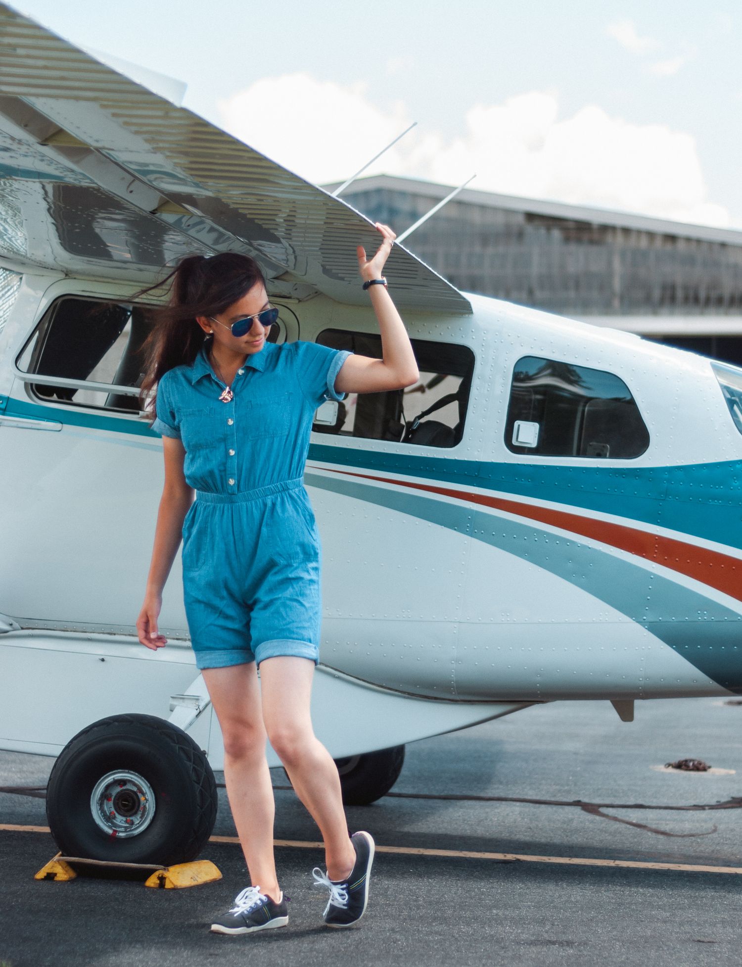 Woman holding loosely the the wing of a plane in Charlotte, North Carolina