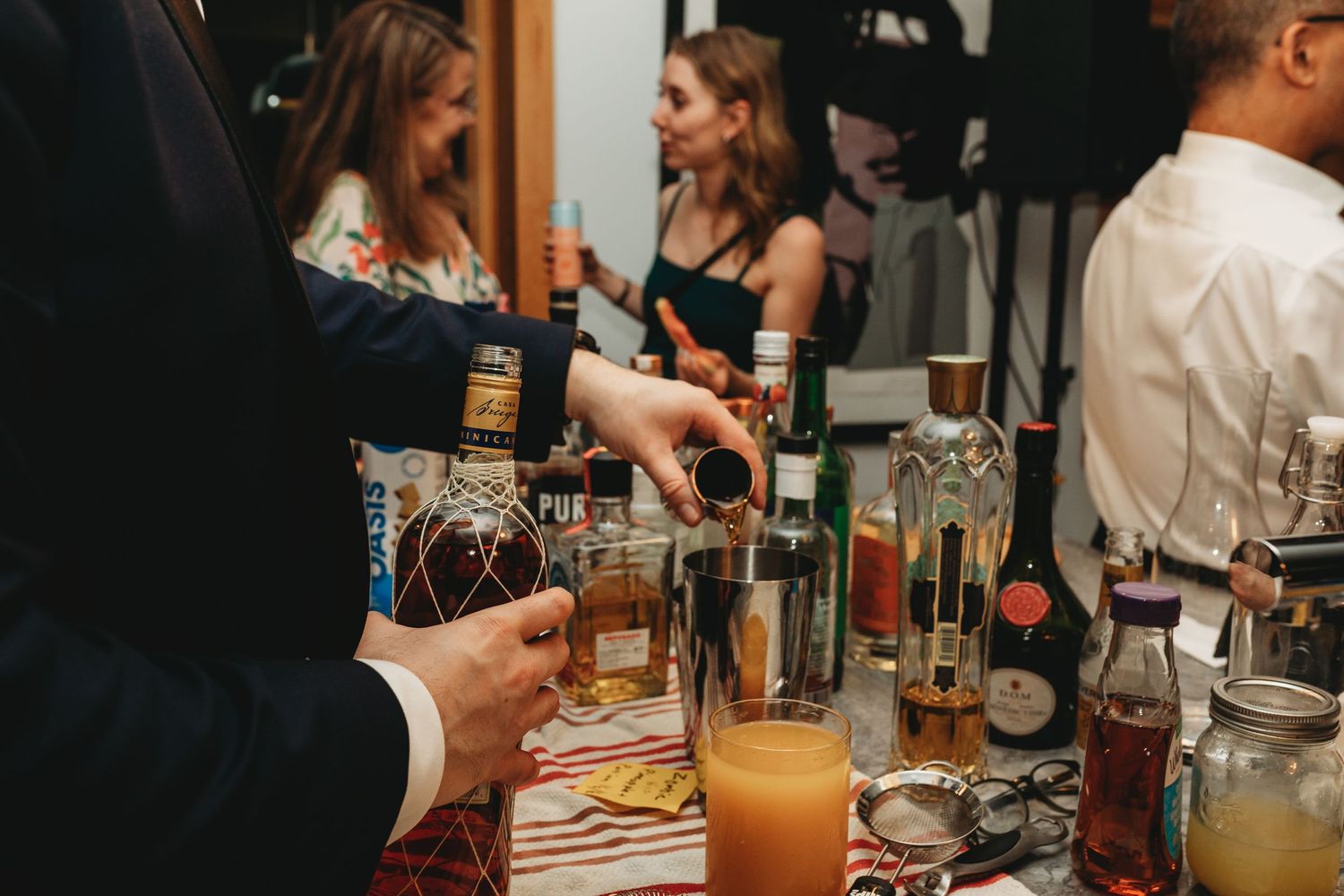 Bar setup at a wedding reception with various bottles and cocktail ingredients.
