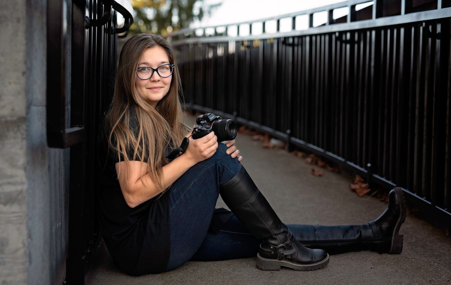 Lady in glasses sitting on the concrete walkway in Scottsburg Indiana holding her camera
