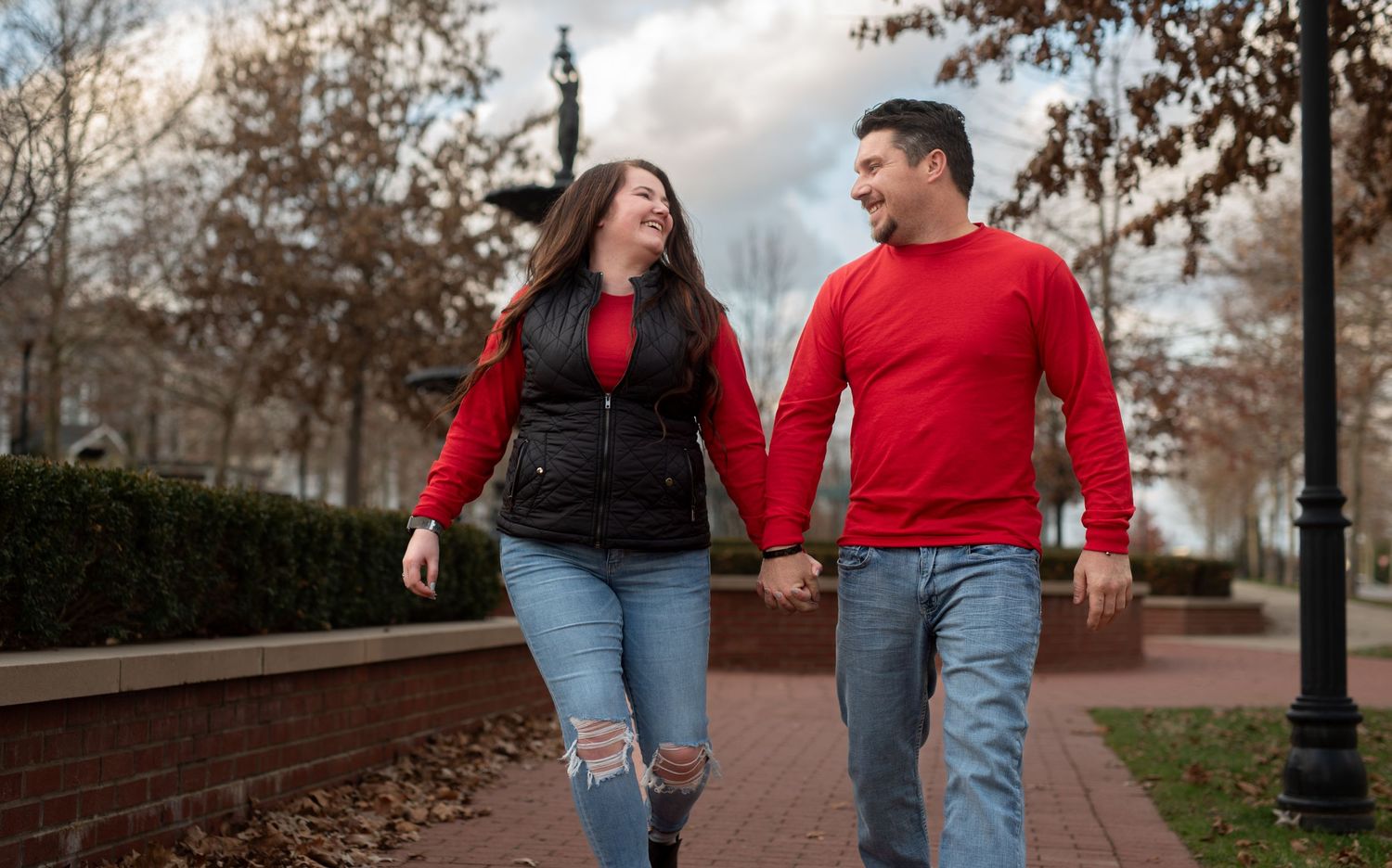 Couple in red smiling and walking in Louisville neighborhood