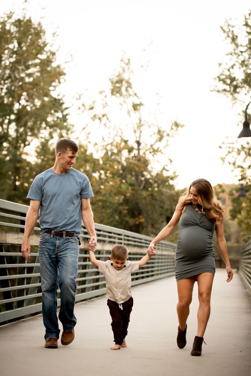 Family of 3 walking over the bridge at Savannah River Rapids.