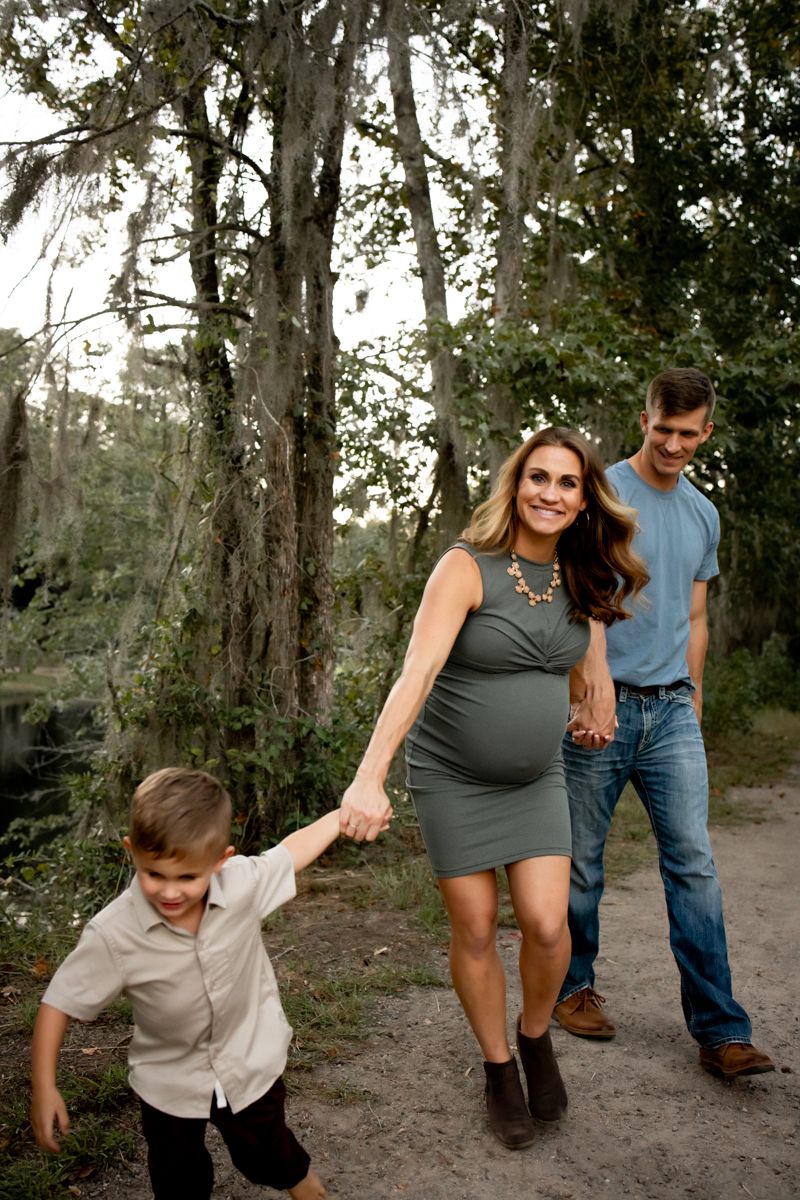 Soon to be big brother holding mom's hand leading his mom and dad down the trail at Savannah River Rapids.