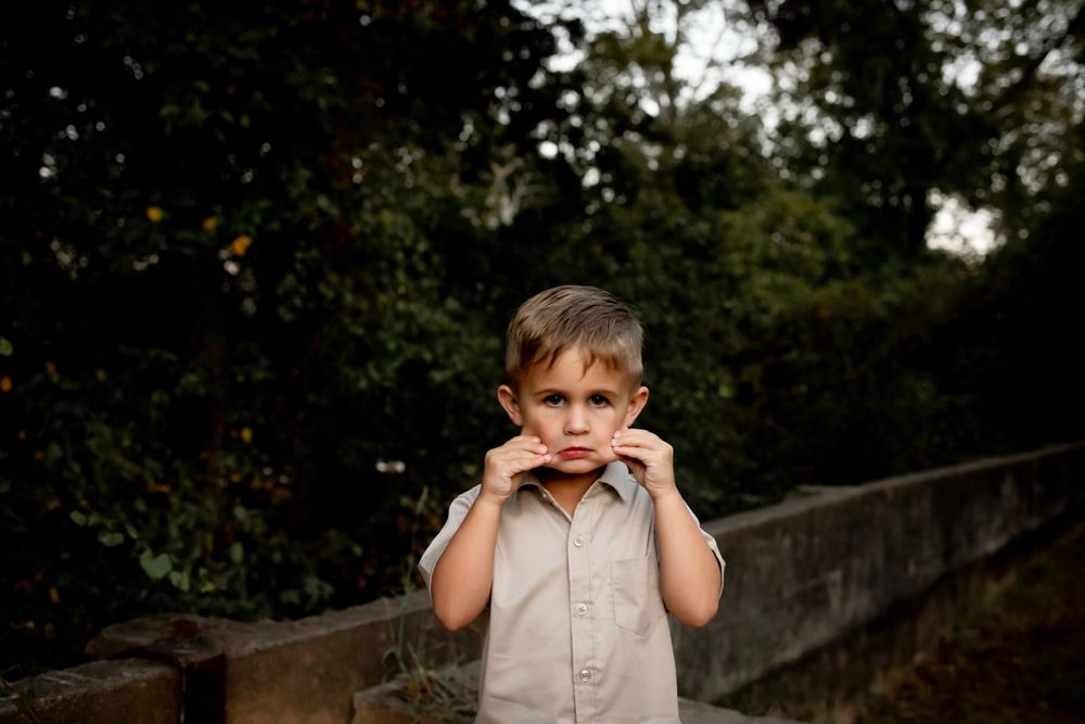 Little boy on the Savannah River Rapids grabbing his own cheeks making faces at the camera.