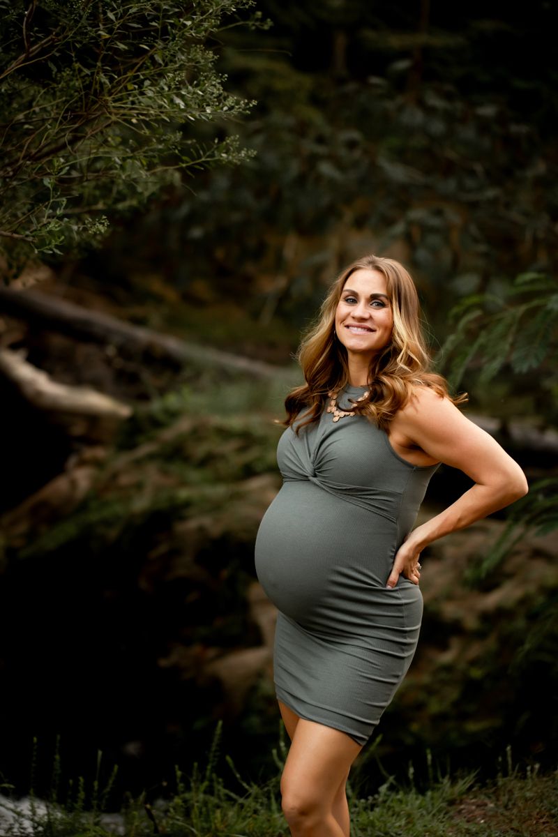 Pregnant woman posing in a green dress at Savannah River Rapids.