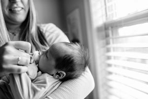 Intimate black and white newborn photography session by window light.