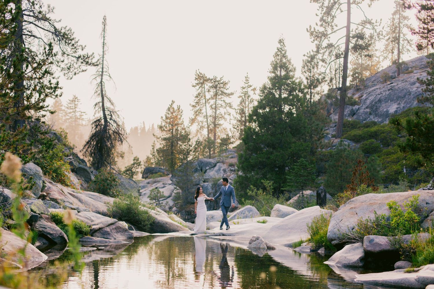 Scenic engagement session at a mountain lake surrounded by pine trees.