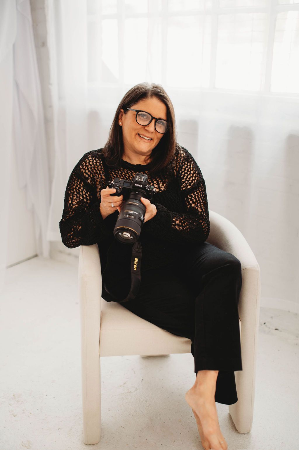 Rhode Island Photographer in studio posing with Nikon camera.