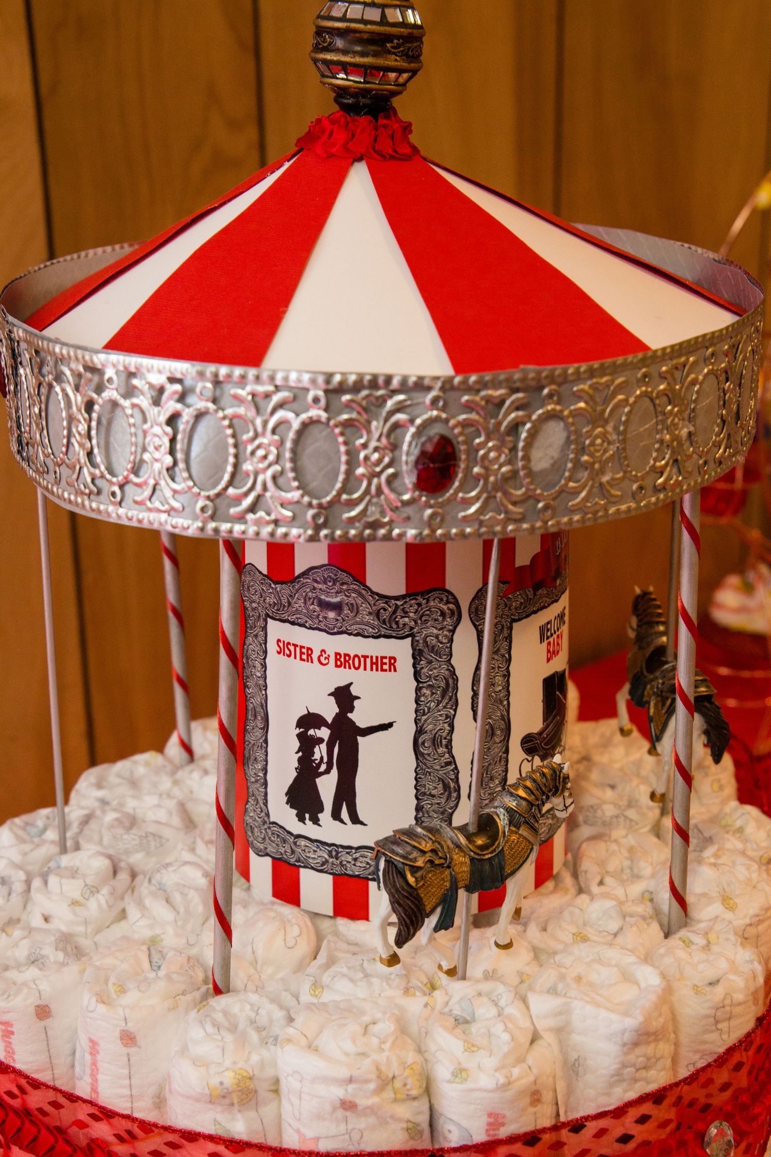 Vintage circus-themed carousel display with illustrated panels and silver ornate trim.
