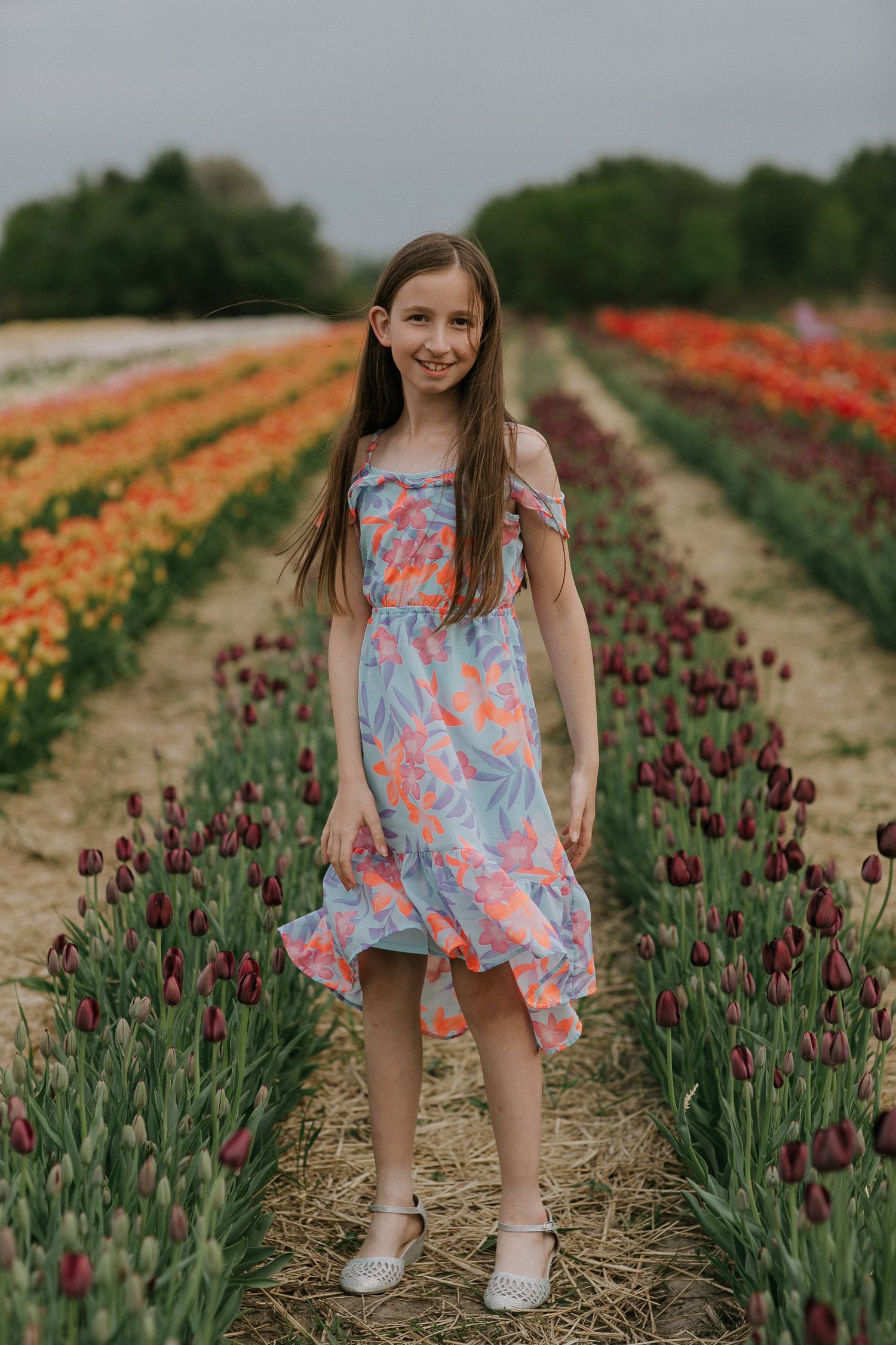 Teenager posing for family photos in a vibrant tulip field near Ottawa, ON.