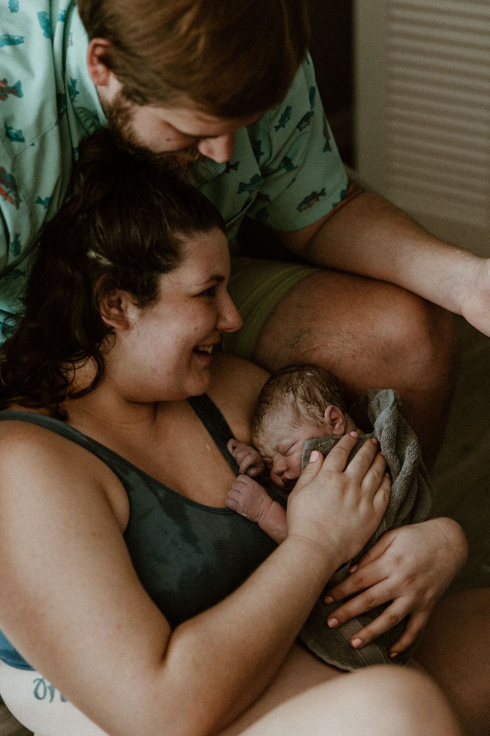 Intimate family moment captured in moody lighting with gentle embraces.