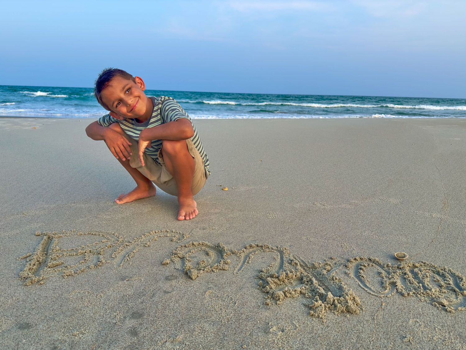 Writing in the sand on a peaceful beach at dusk.