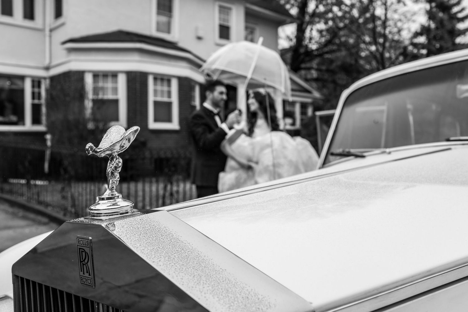 Vintage Rolls Royce hood ornament detail with soft focus background in monochrome.