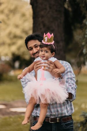 Outdoor portrait with pink tutu dress and crown against autumn background.