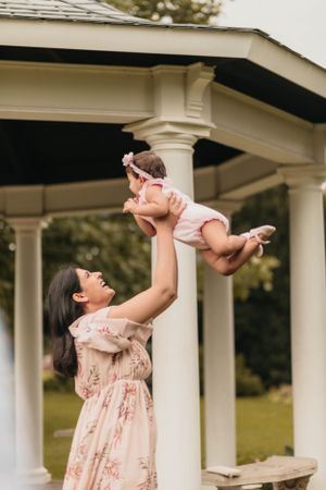 Playful moment under white gazebo during outdoor family photoshoot.