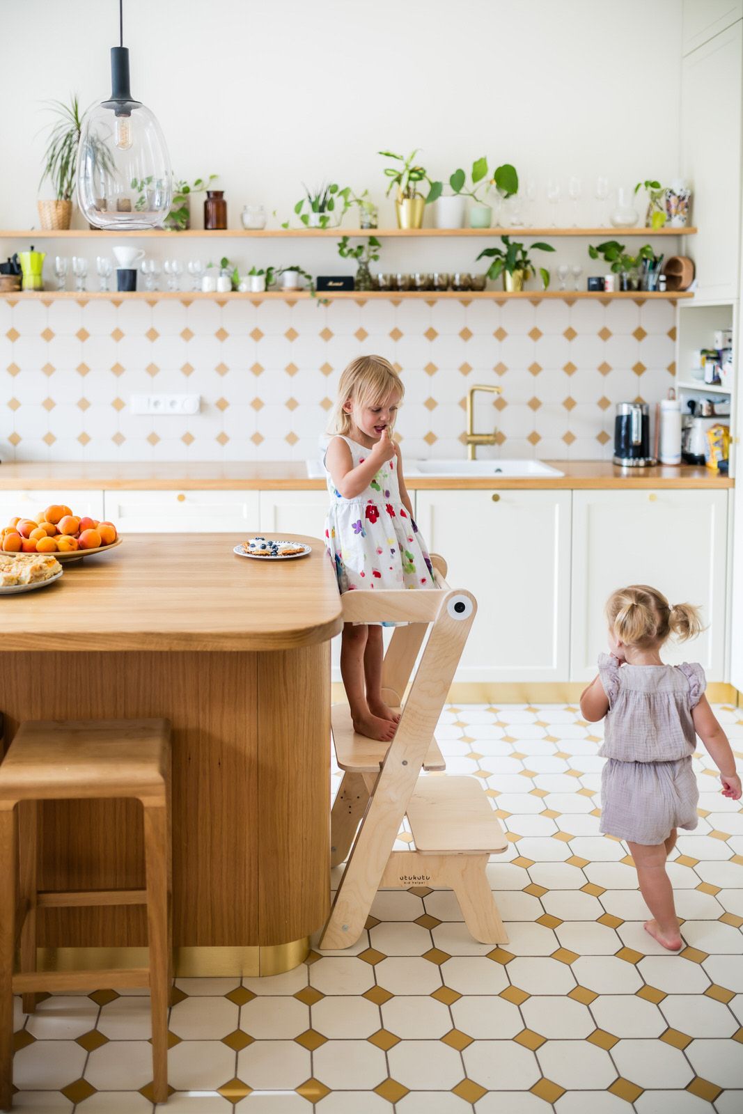 Modern white kitchen with wood accents and retro tile flooring.