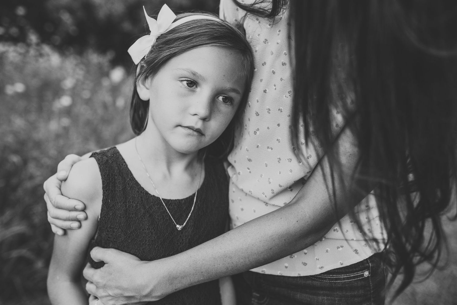 Soulful young girl sad and being held by her mom