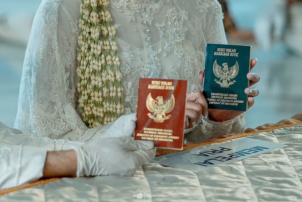 Close-up of Indonesian passports being held during a wedding ceremony.