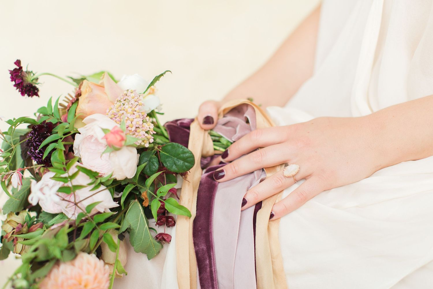 A series of delicate floral bouquets with soft pink roses and burgundy accents being held by hands in outdoor settings euridge manor
