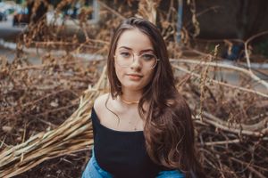 Autumn fashion portrait with dried branches and blue denim styling.