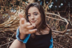 Artistic portrait with an outstretched hand reaching towards the camera.