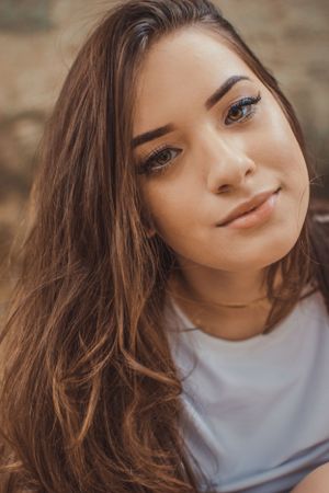 Portrait with subtle makeup and textured background.