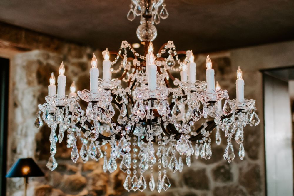 An elegant crystal chandelier with multiple tiers of hanging crystals and candle-style lights.