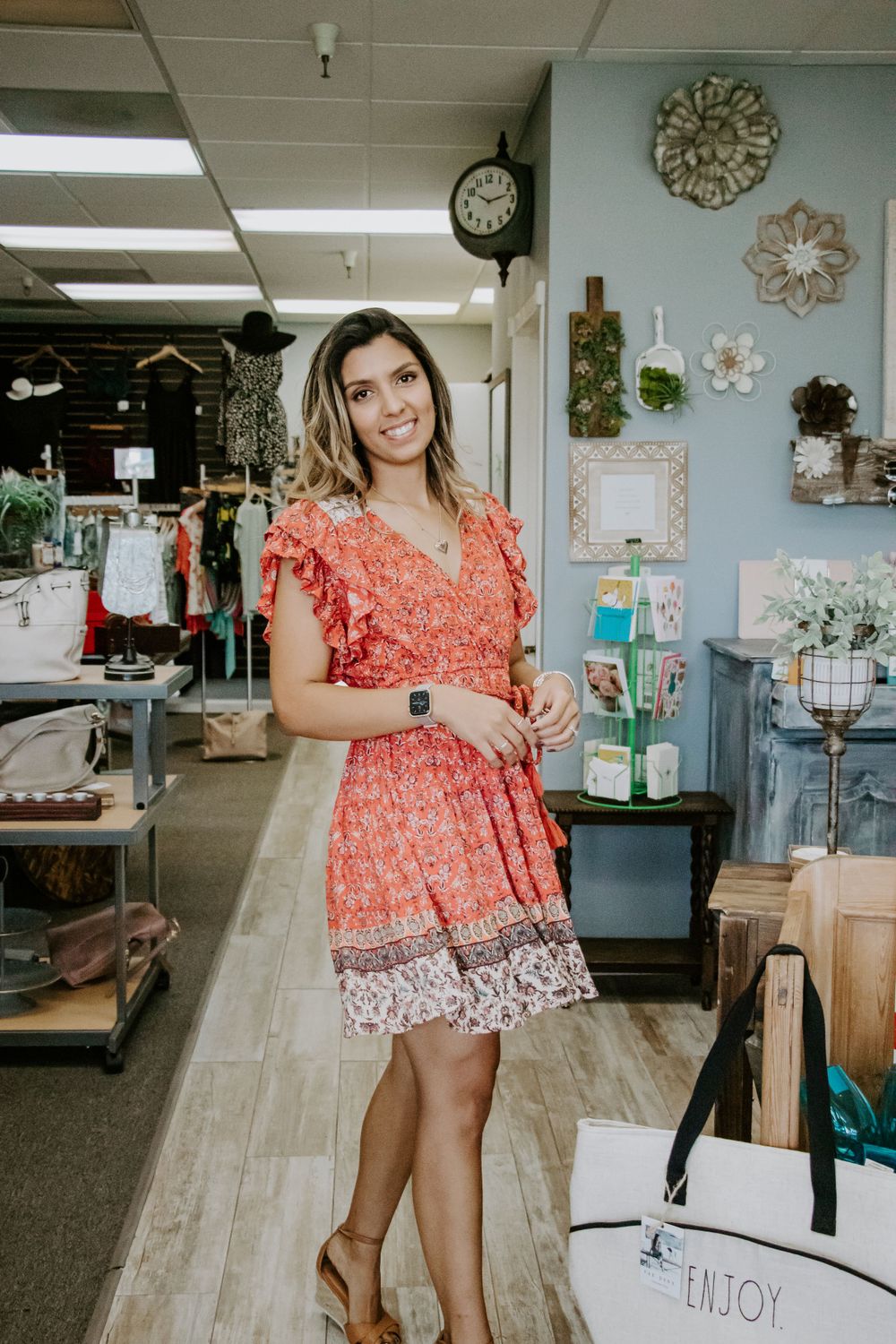 A bright retail store interior with decorative wall art and clothing displays.
