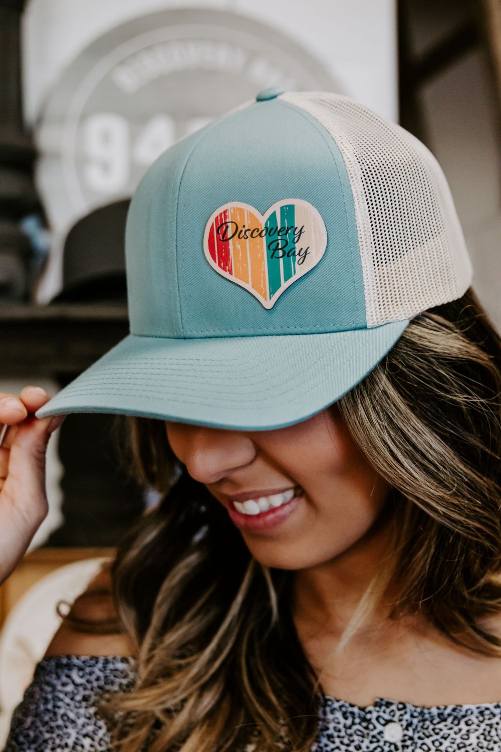 Light blue and white trucker hat with heart patch design.