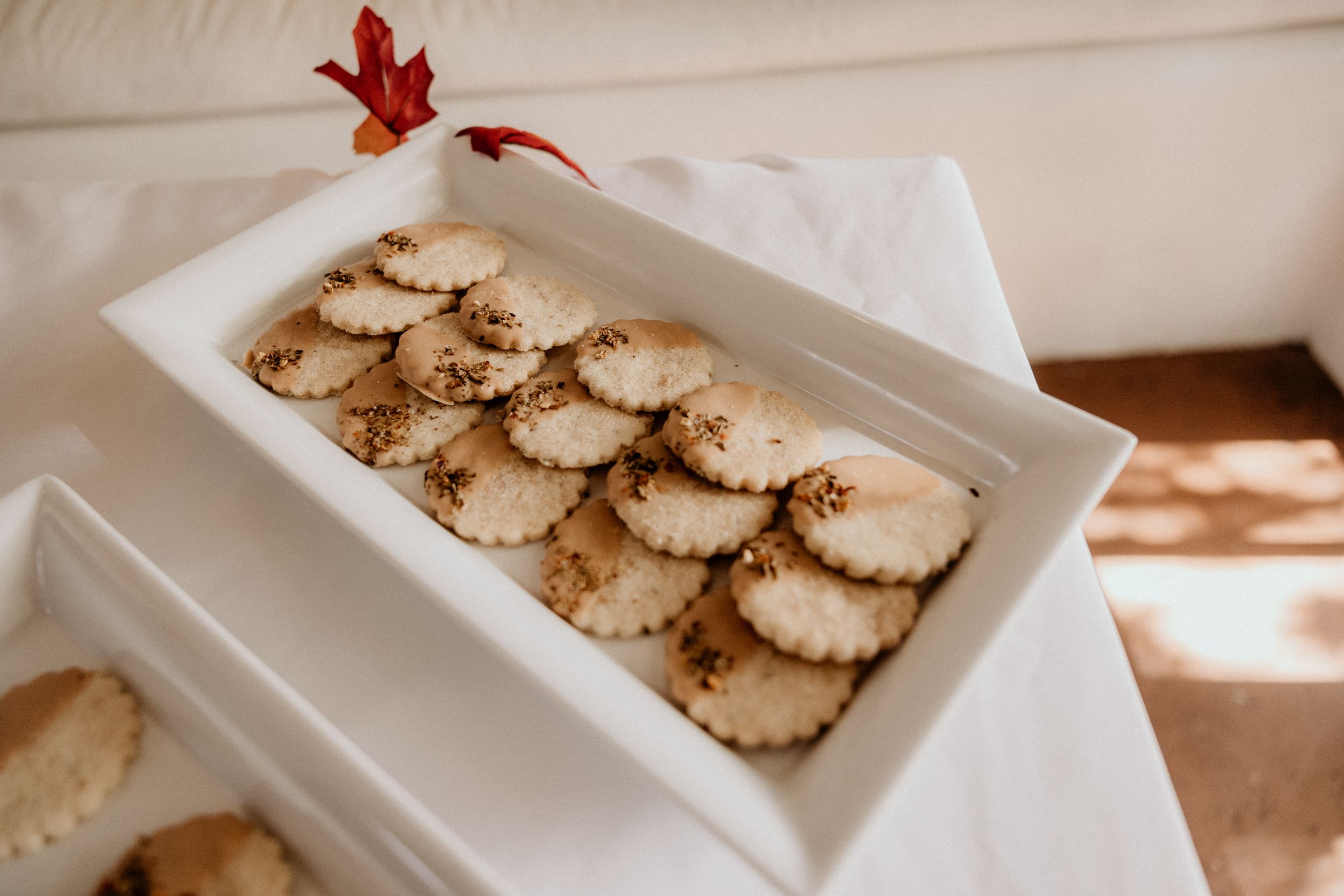 White rectangular dish filled with round sprinkled shortbread cookies for wedding reception.