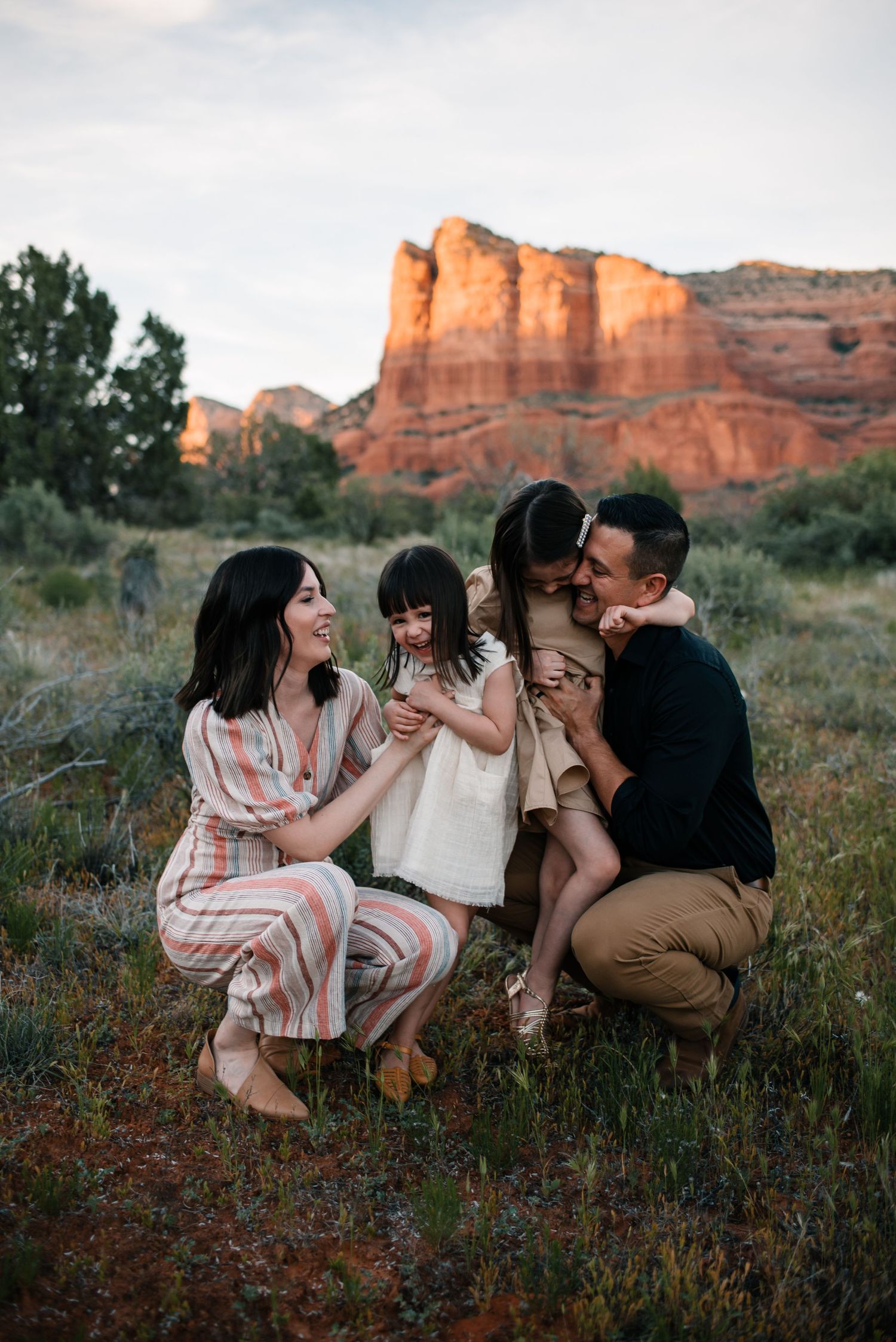 Group enjoying a casual gathering in front of red rock formations at sunset.