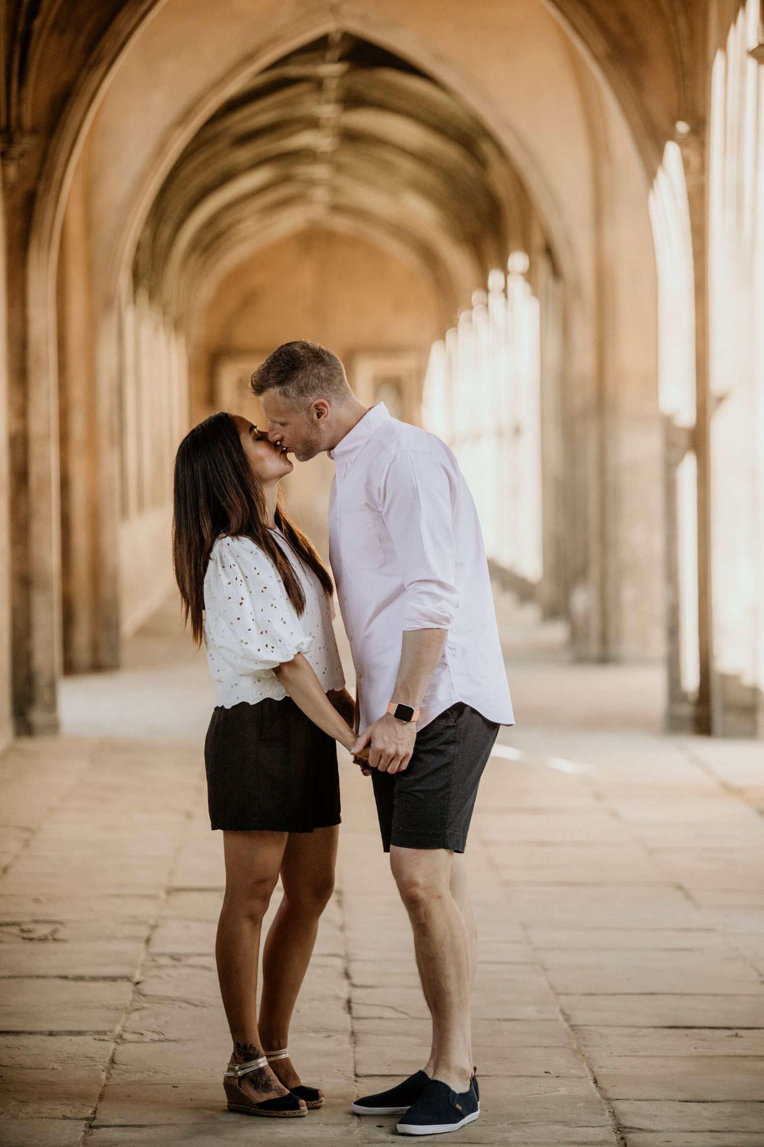couple kissing under archway in Cambridge